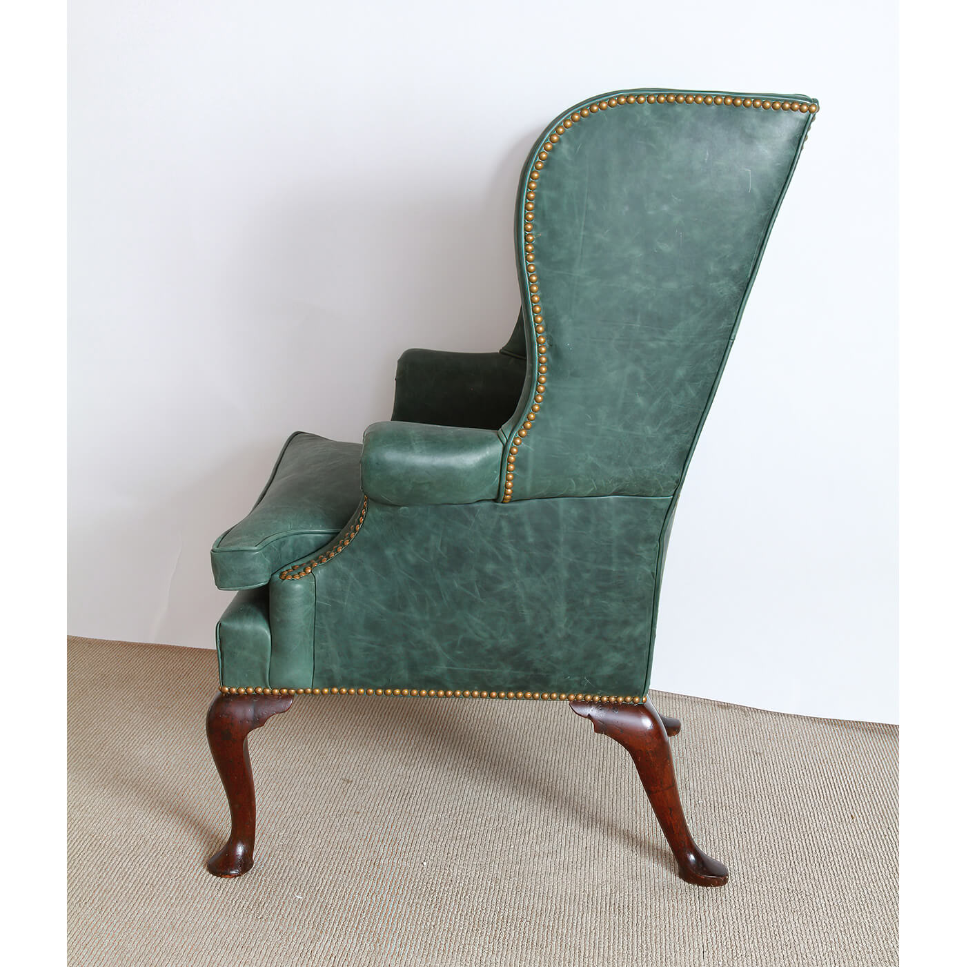 Side profile of green wingchair showing detailed construction.