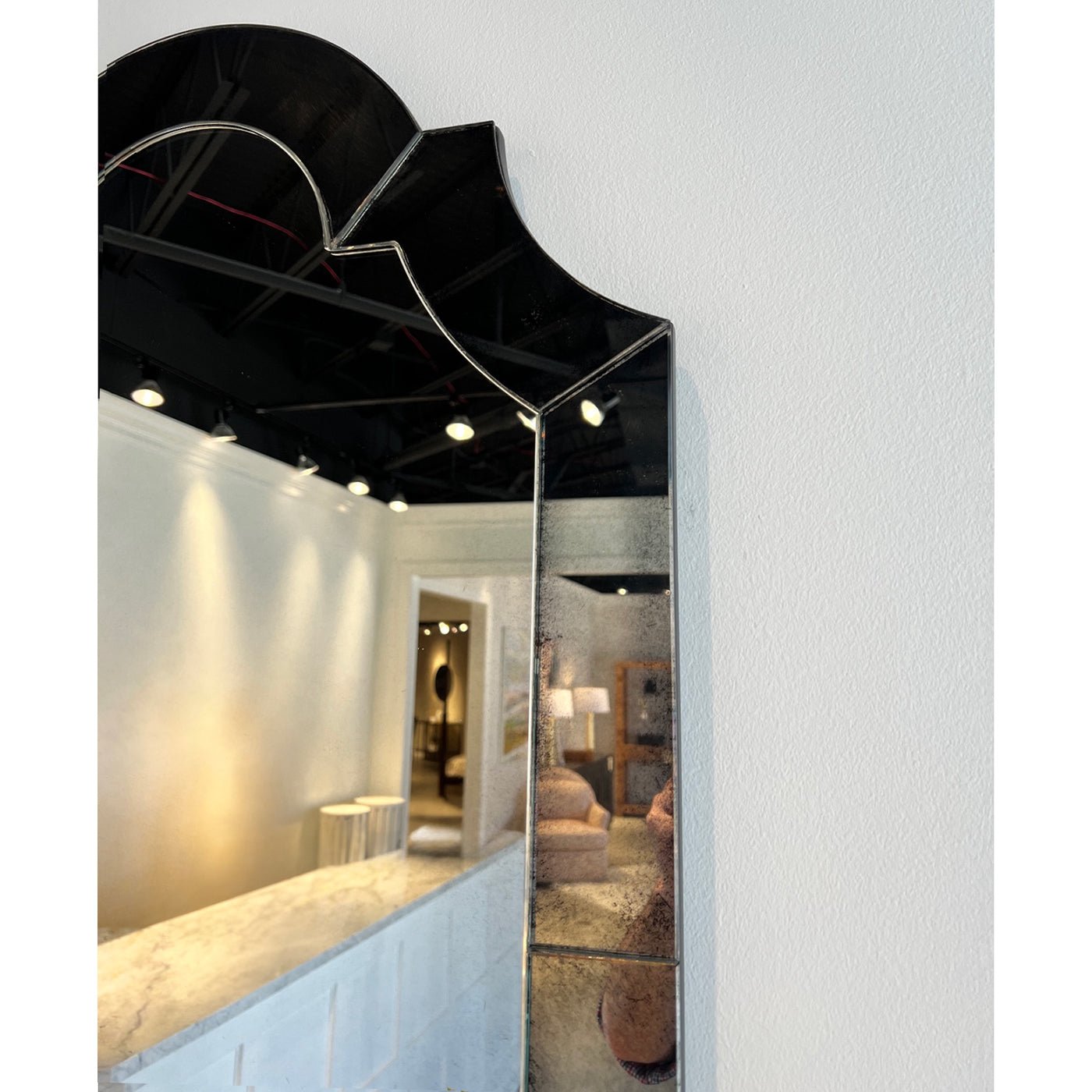 Side view of ornate mirror reflecting elegant interior.