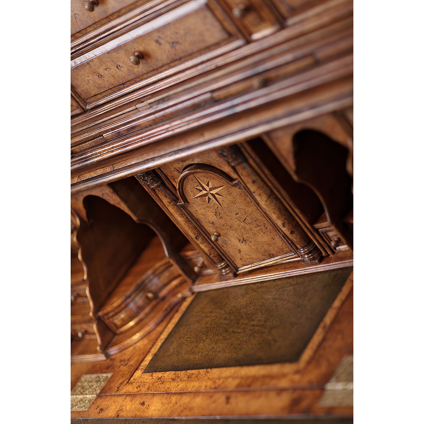 Ornate carvings inside Queen Anne secretary bookcase, star motif.