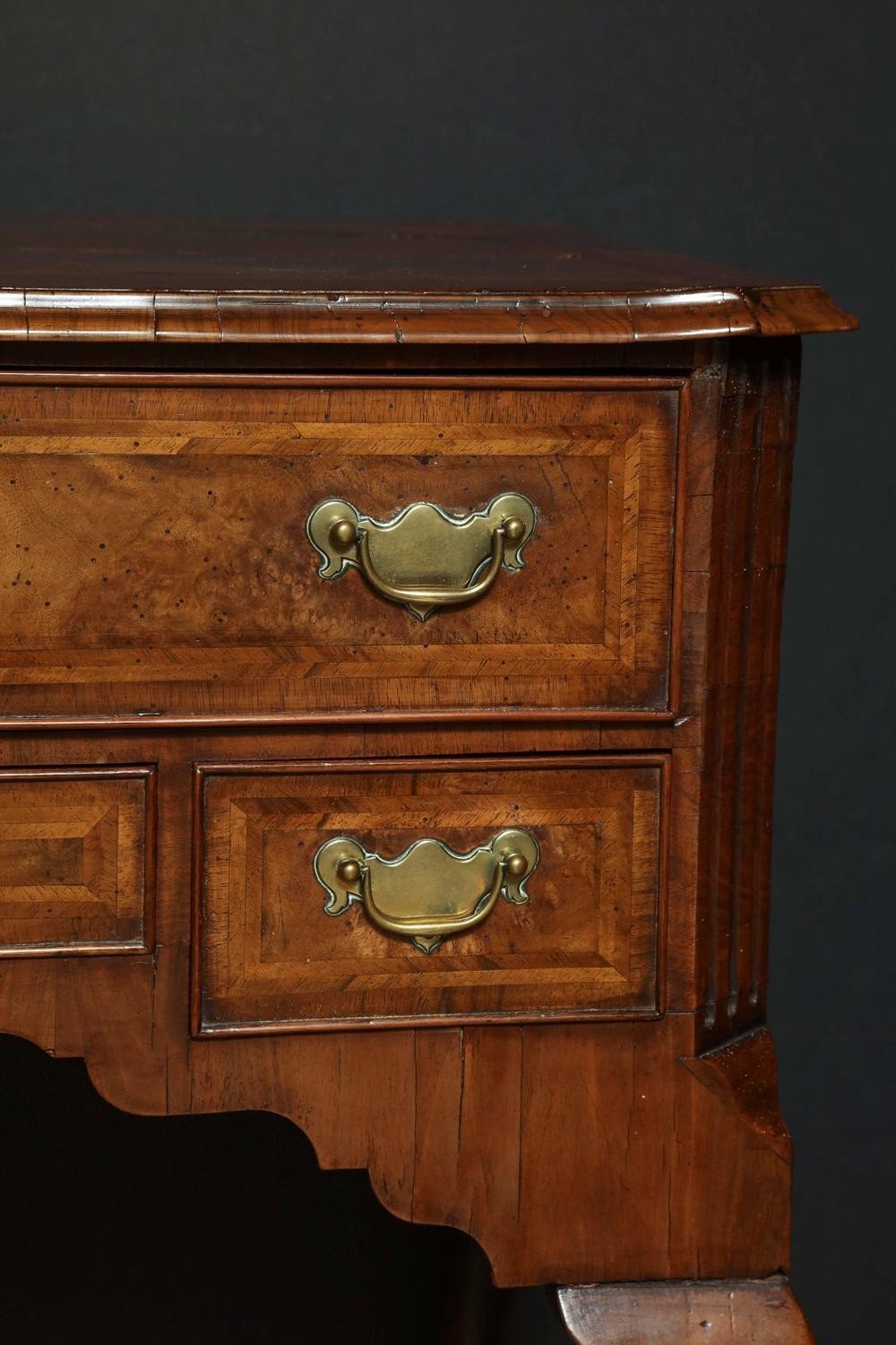 Close-up of brass handles on Queen Anne walnut lowboy.
