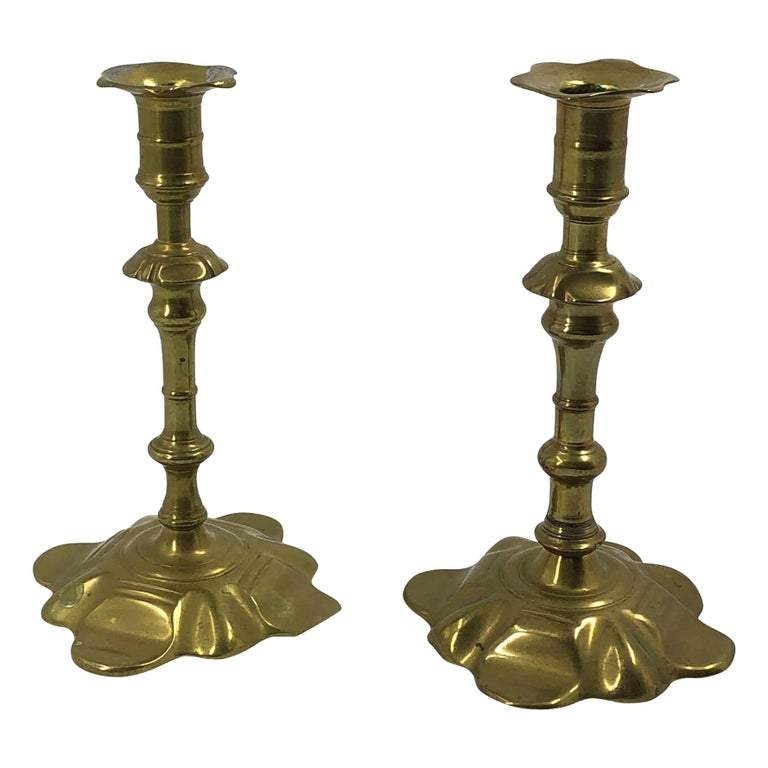 Pair of Queen Anne brass candlesticks side view.