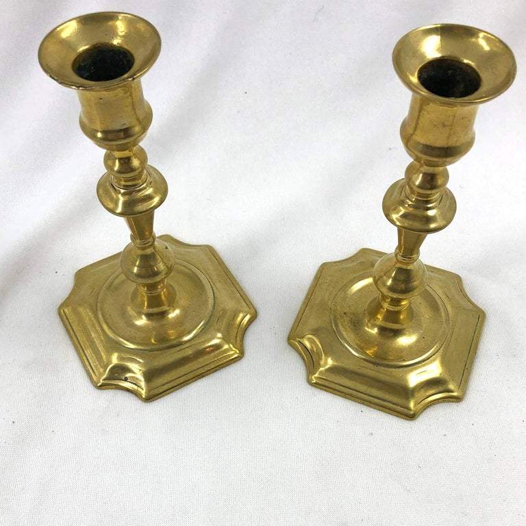 Overhead view of Queen Anne candlesticks, brass surface.