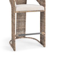 Detail of the cream seat cushion, woven rattan frame, slim footrest and rounded lower rail