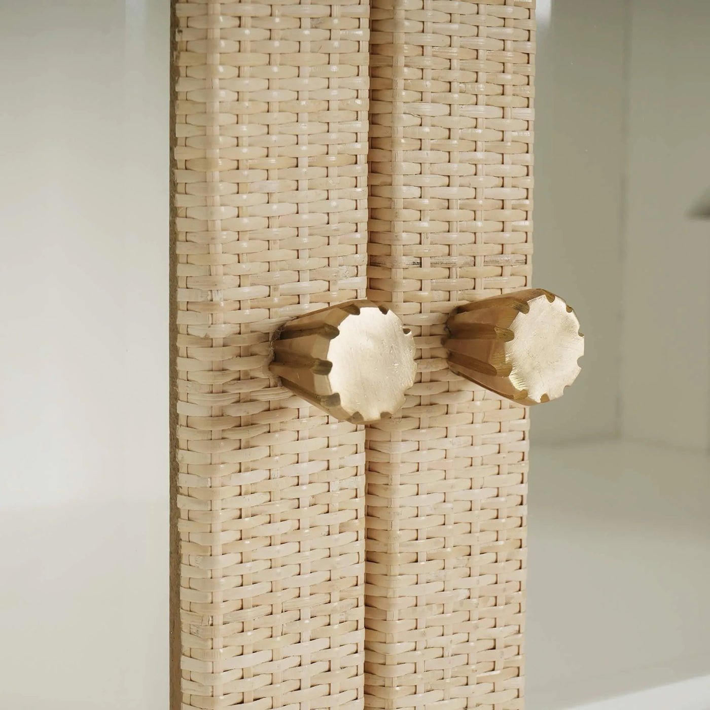 Close-up of cabinet door knobs on rattan cabinet.