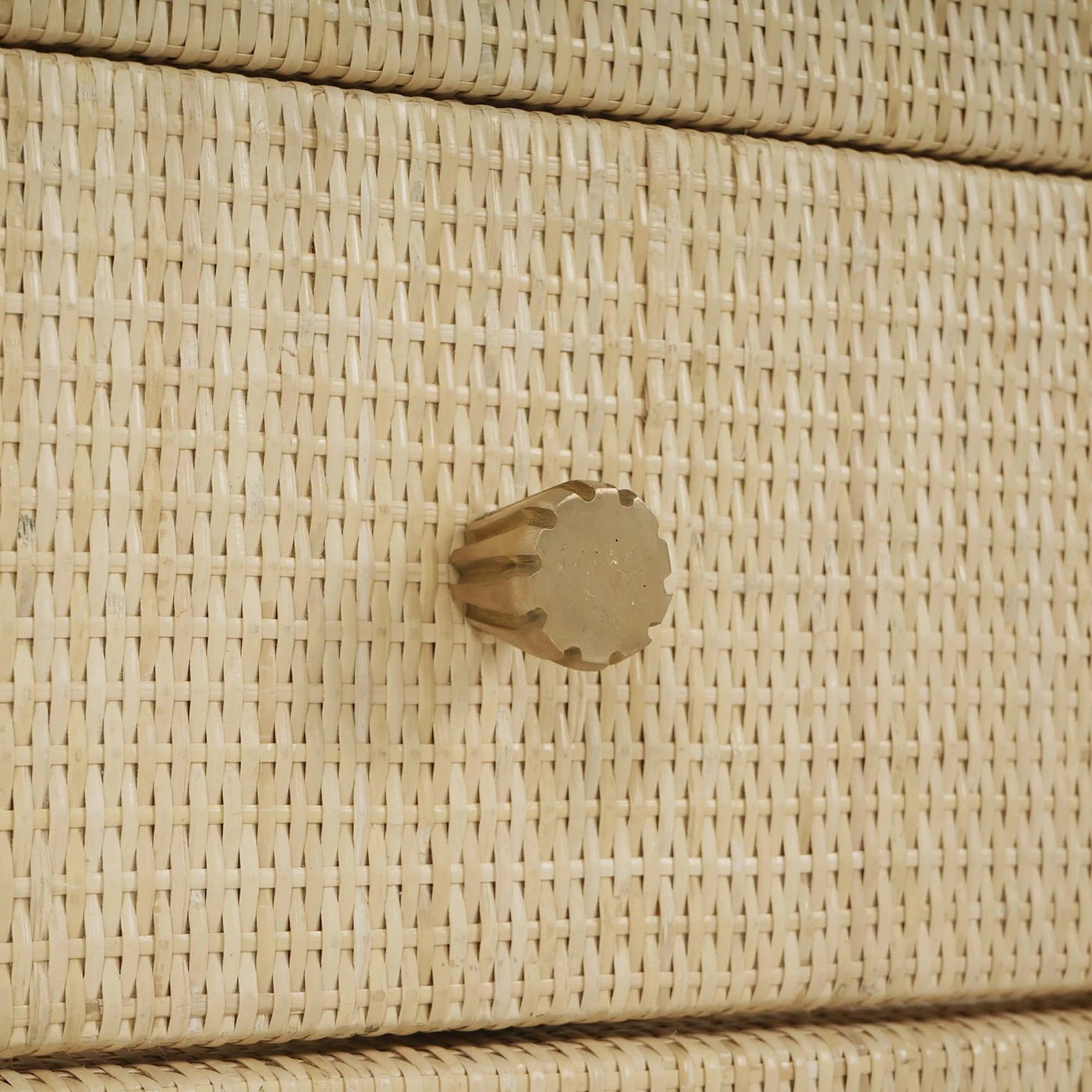 Close-up of drawer knob on rattan wrapped cabinet.
