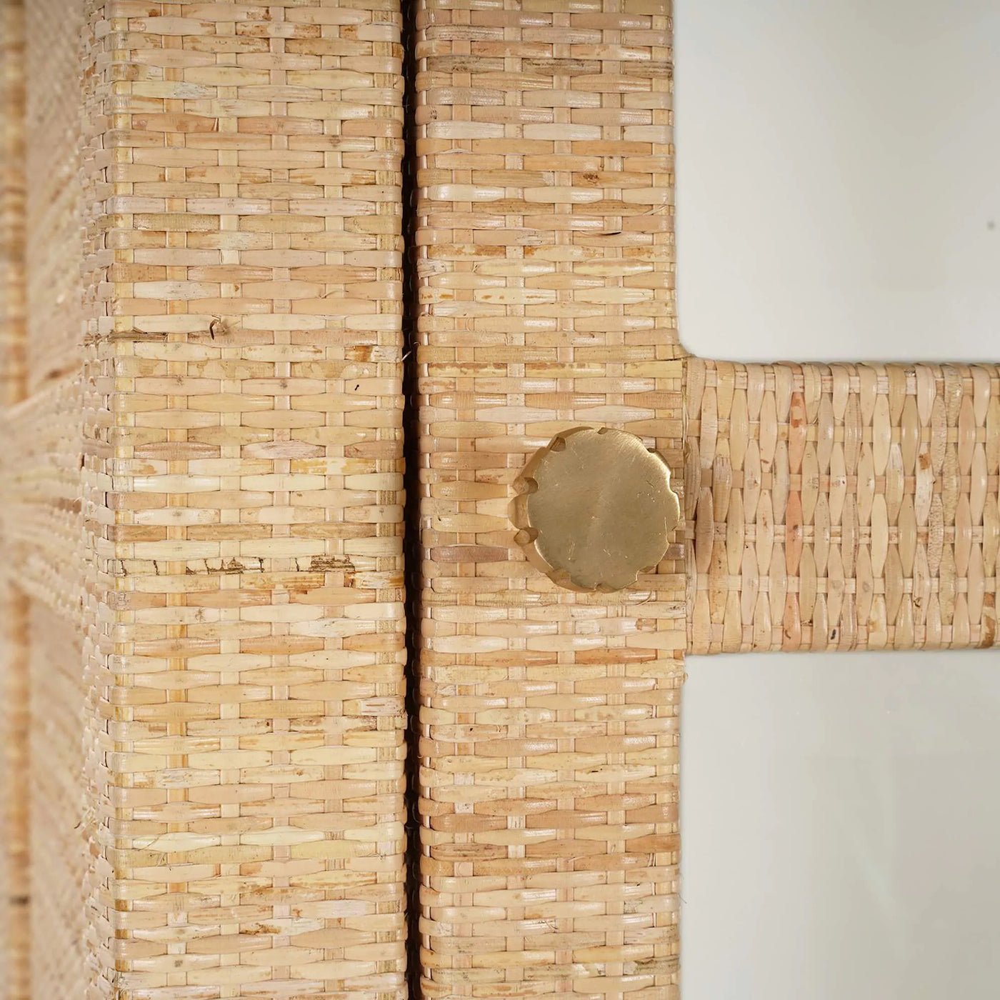 Close-up of rattan cabinet door knob and texture.