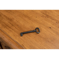 Antique-style key on reclaimed pine credenza surface.