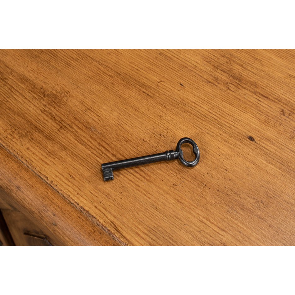 Antique-style key on reclaimed pine credenza surface.