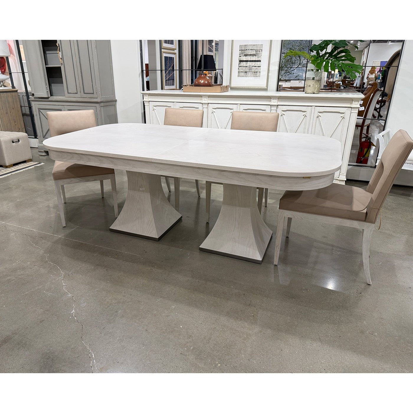 Dining table with chairs in a showroom setting.