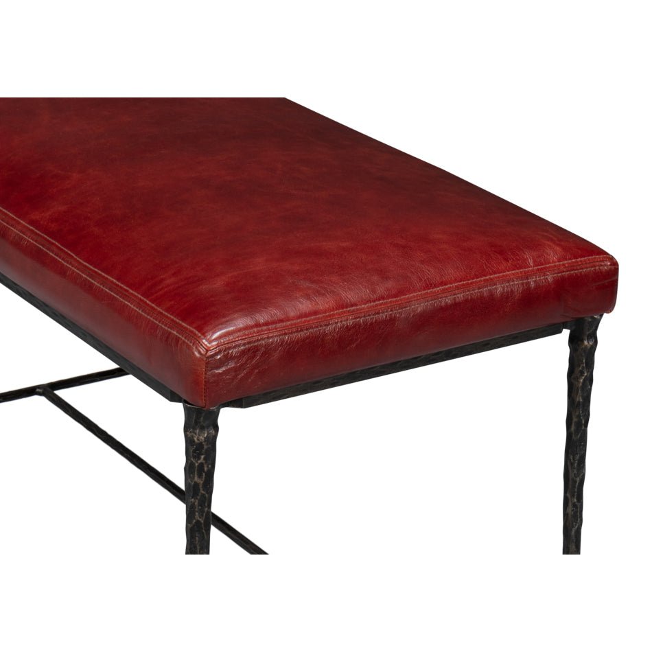Corner detail of red leather seat on rustic bench.