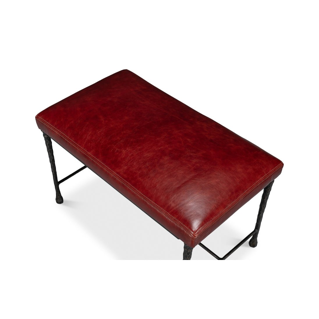 Detailed view of red leather seat on rustic bench.