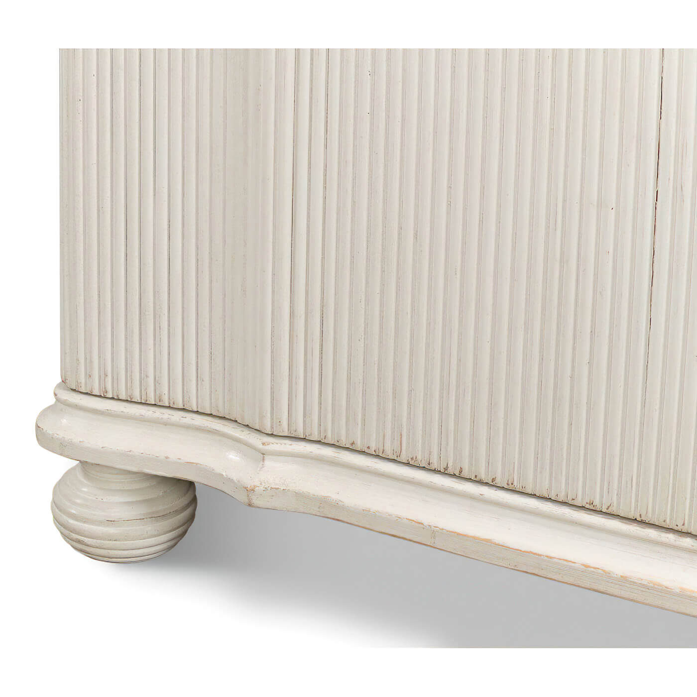 Close-up of cabinet base, reeded antique white design.