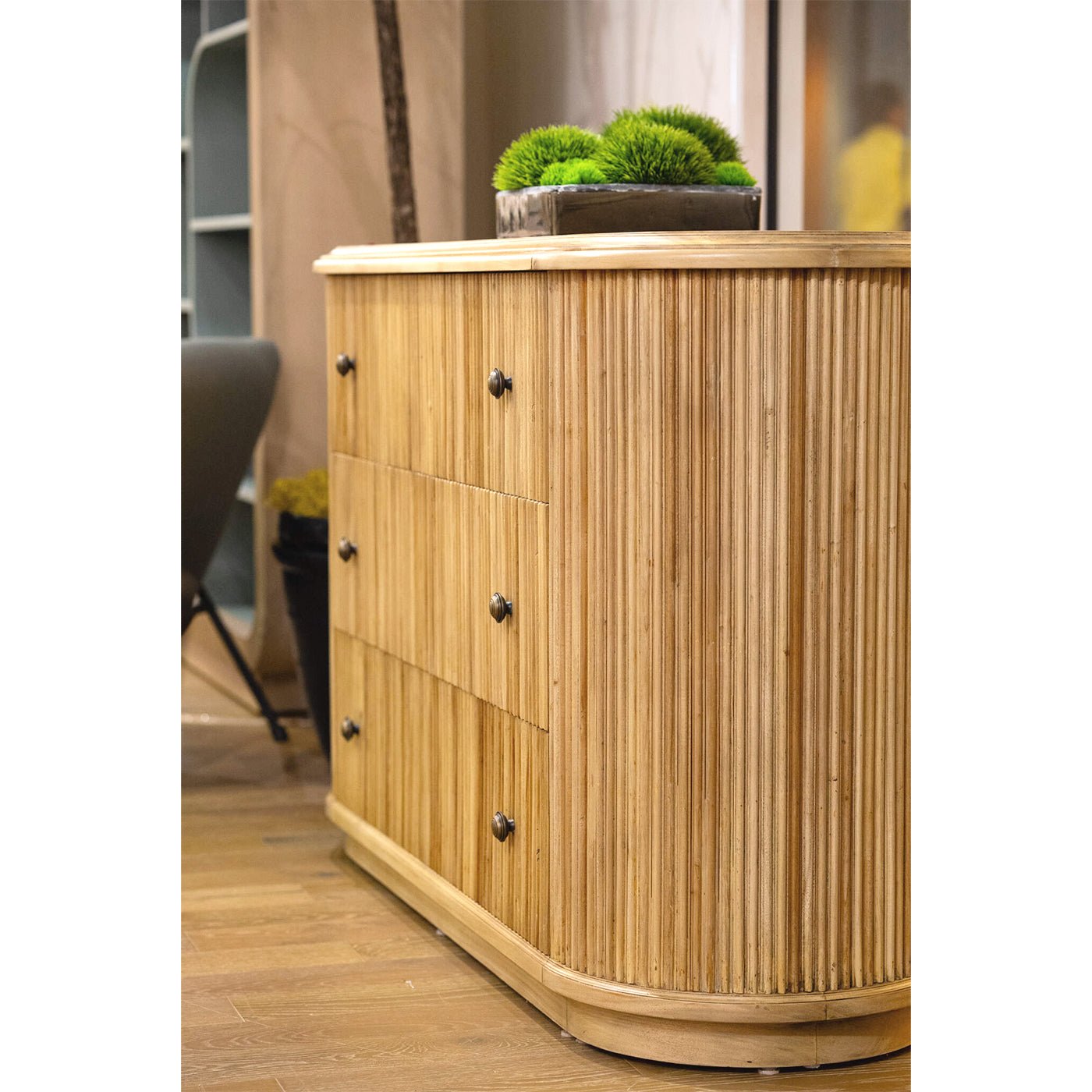 Contextual shot of dresser, wooden floor, with decor.
