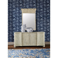 Buffet cabinet against dark floral wallpaper, decorative items on top.