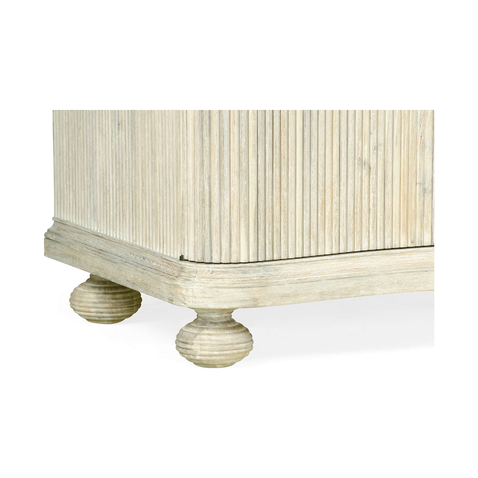 Close-up of reeded cabinet base, detailed foot design.