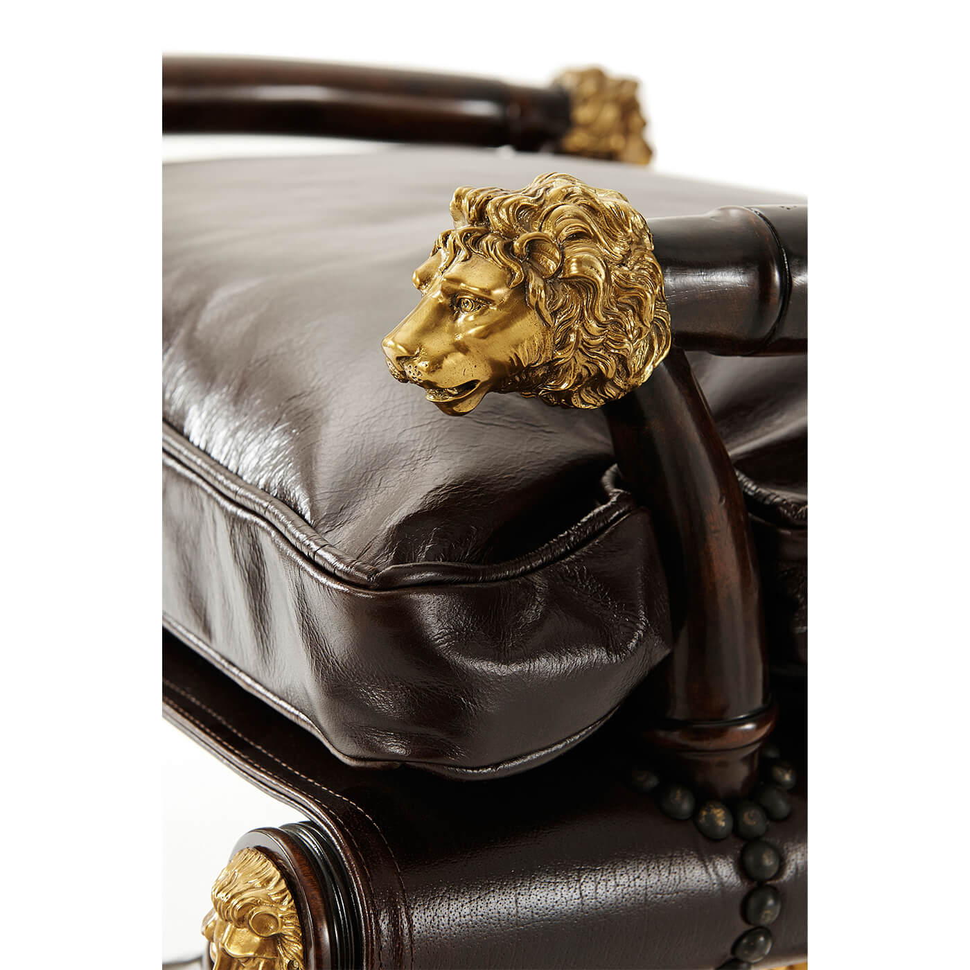 Close-up of regency mahogany stool cushion and lion adornment.