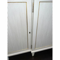 Detailed shot of Regency credenza's door hinge, gold trim.