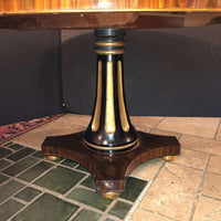 Detailed pedestal base of center table with gold accents.