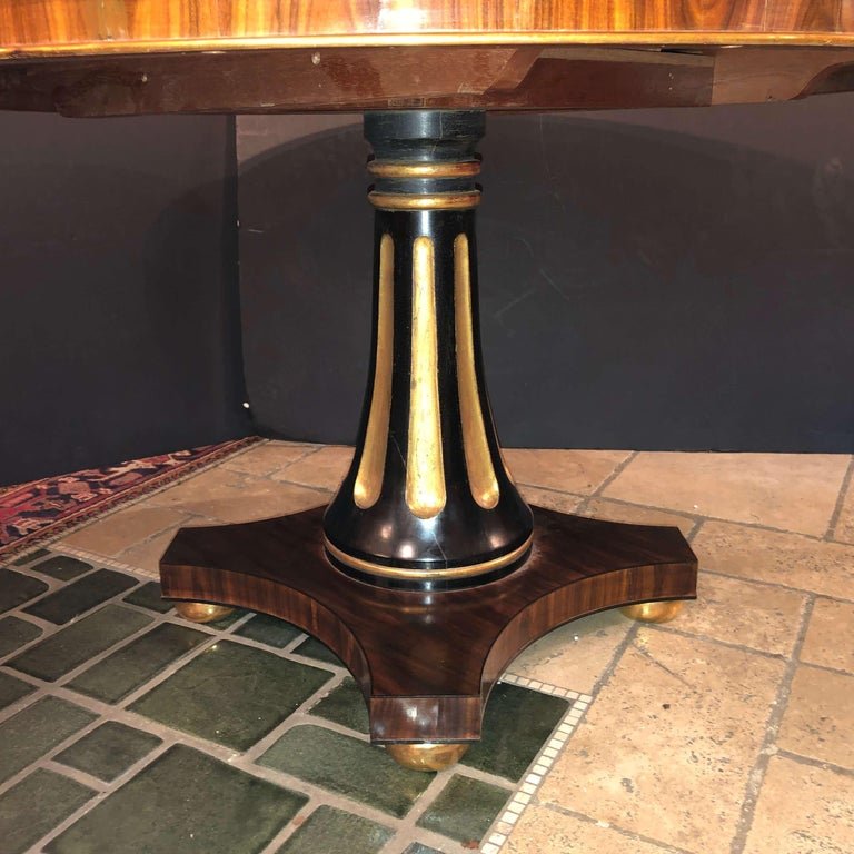 Detailed pedestal base of center table with gold accents.