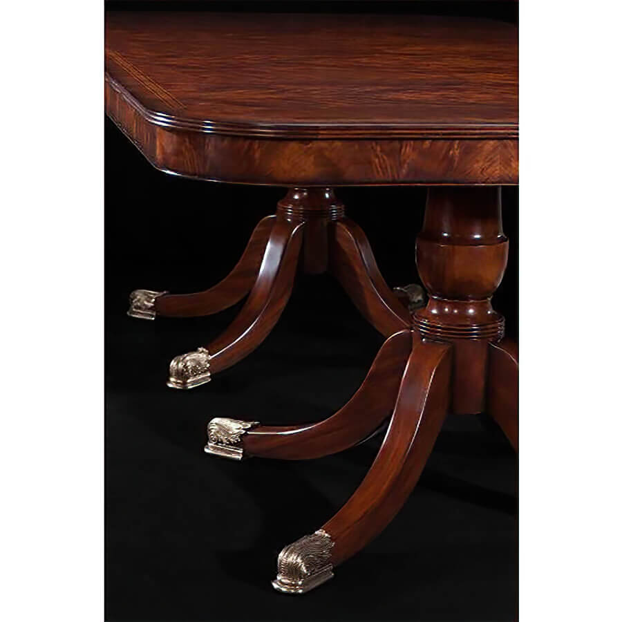 Close-up of mahogany table leg with brass feet.