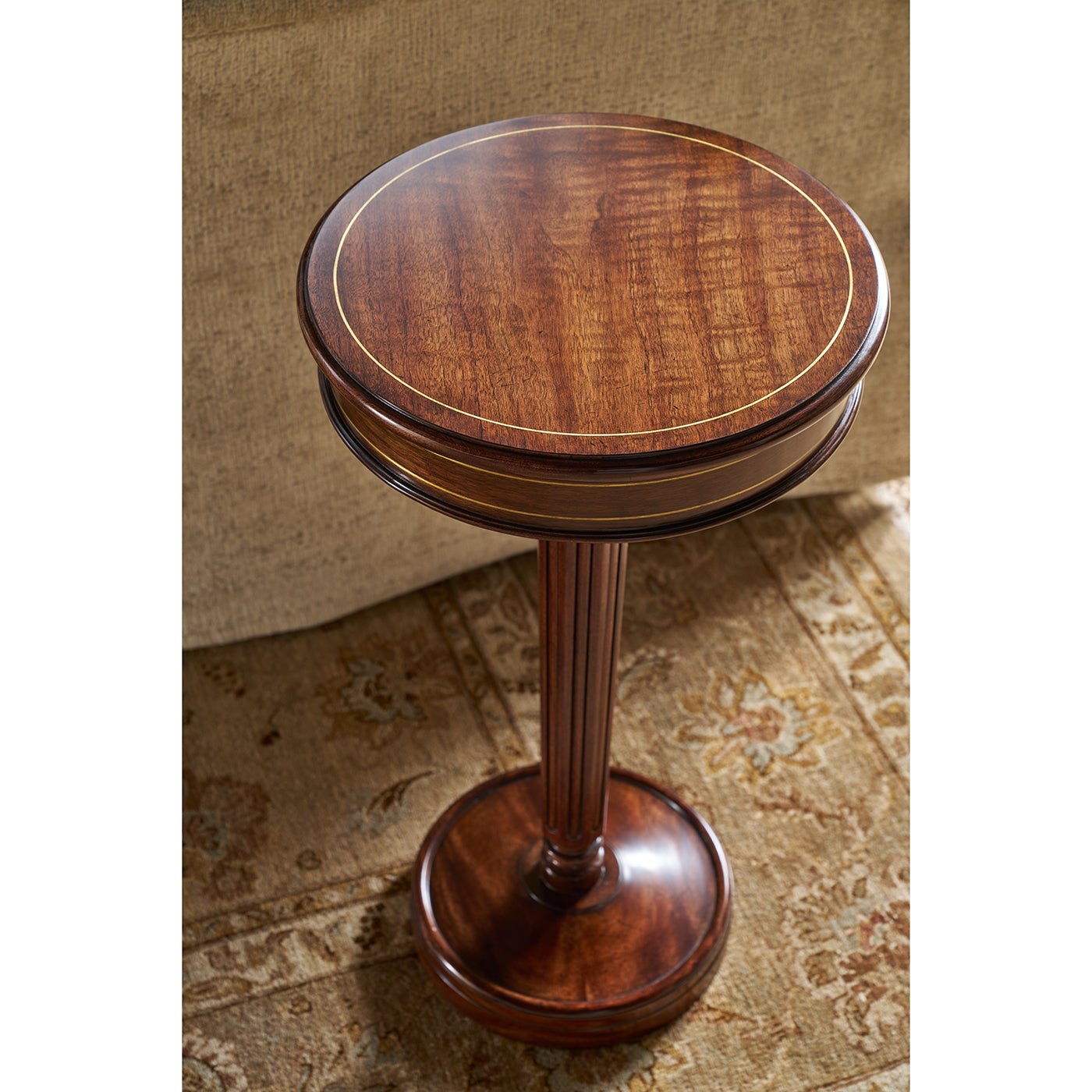 Regency style pedestal accent table, top view, rug background.
