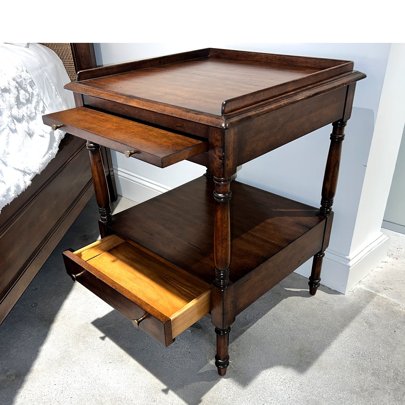 Regency style side table with open top drawer, front view.