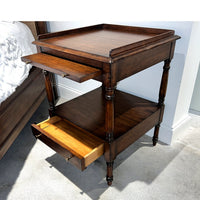 Regency style side table with open top drawer, front view.