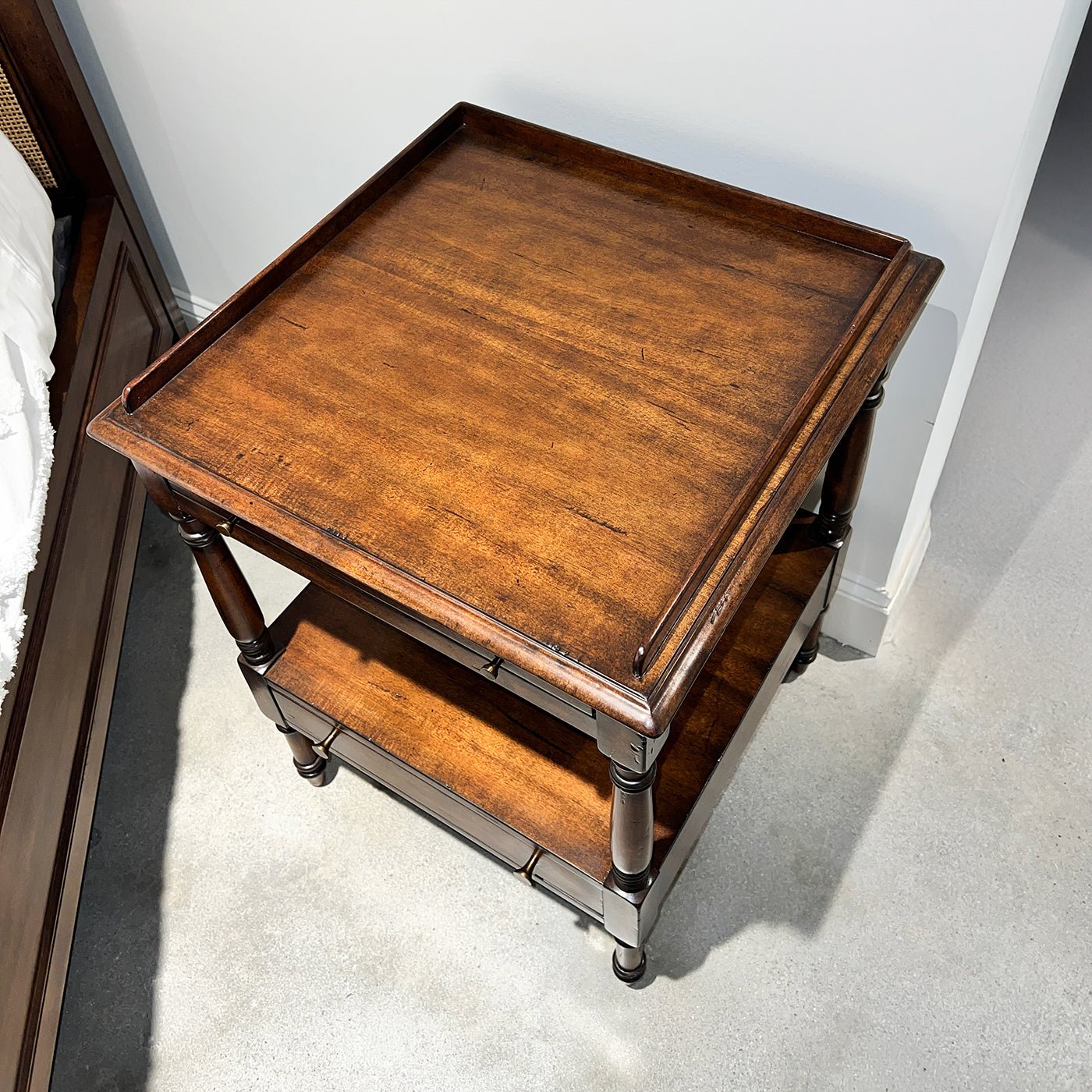 Top view of Regency style side table in bedroom setting.