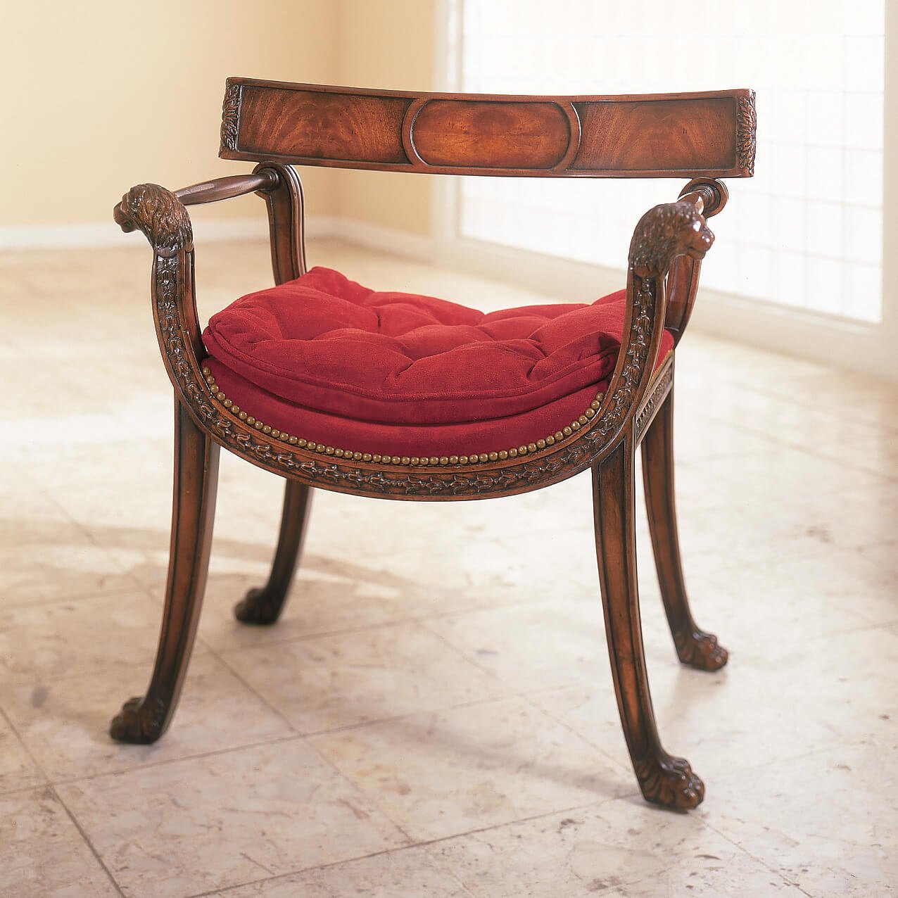 Regency style armchair with red cushion on marble floor.