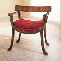Regency style armchair with red cushion on marble floor.