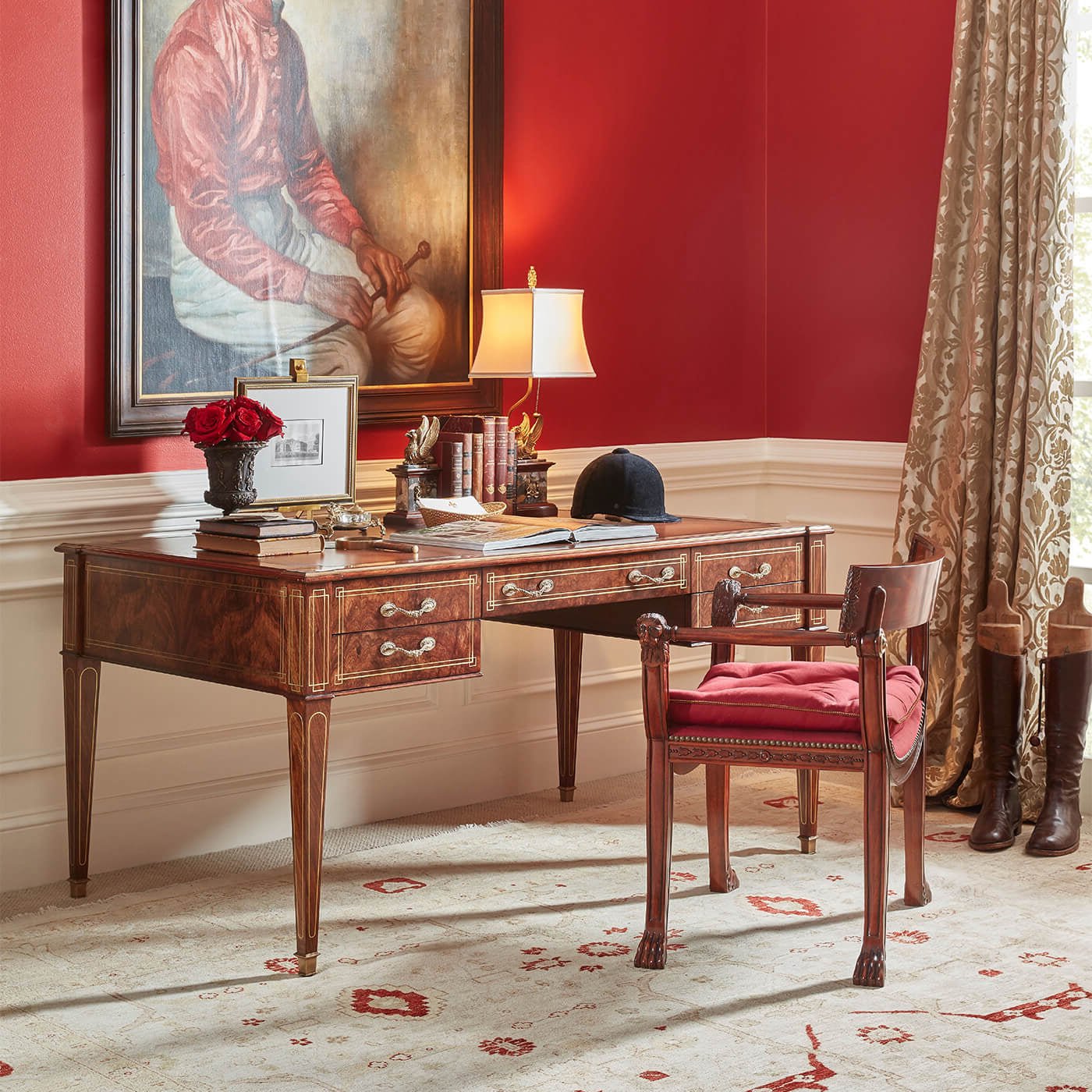Regency style armchair, red cushion, beside wooden desk in room.