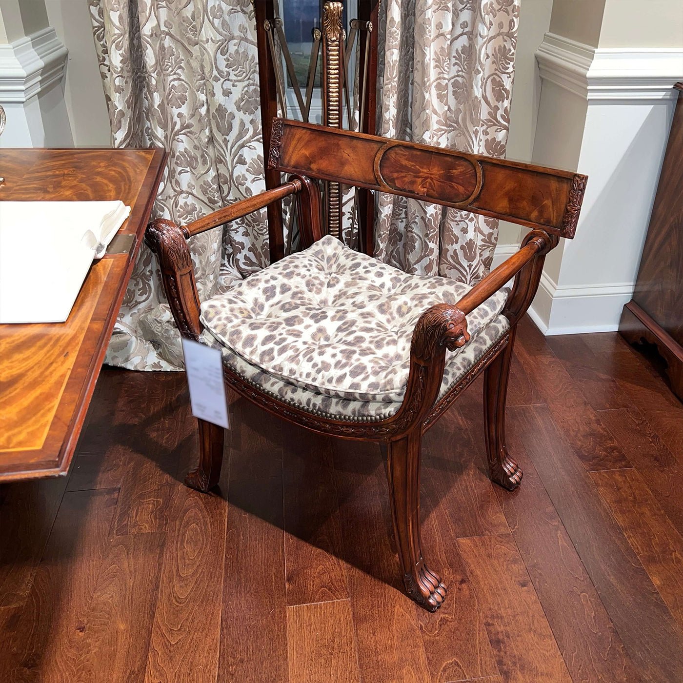 Regency style armchair, leopard print cushion, wooden floor.