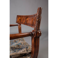 Close-up of Regency armchair backrest, blue pattern cushion.