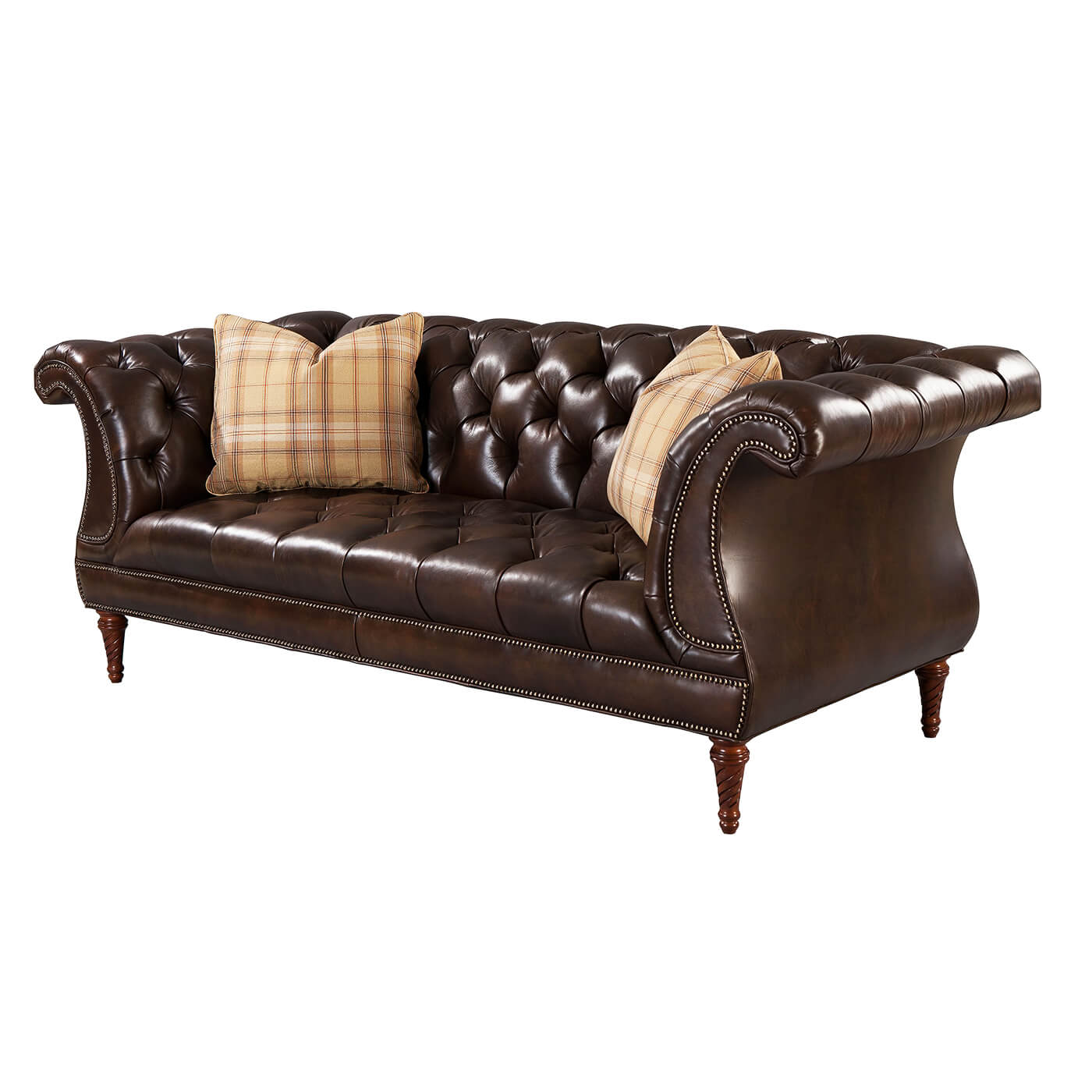 Dark brown leather tufted lyre sofa with plaid pillows.