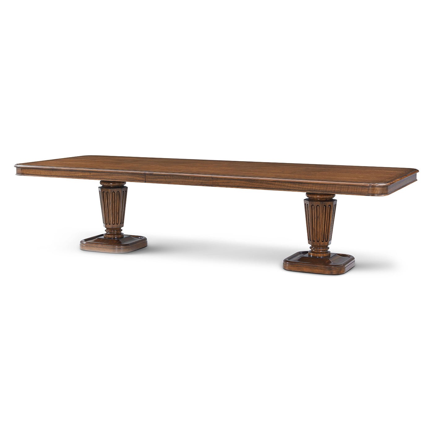 Angled view of walnut dining table, pedestal base detailed.