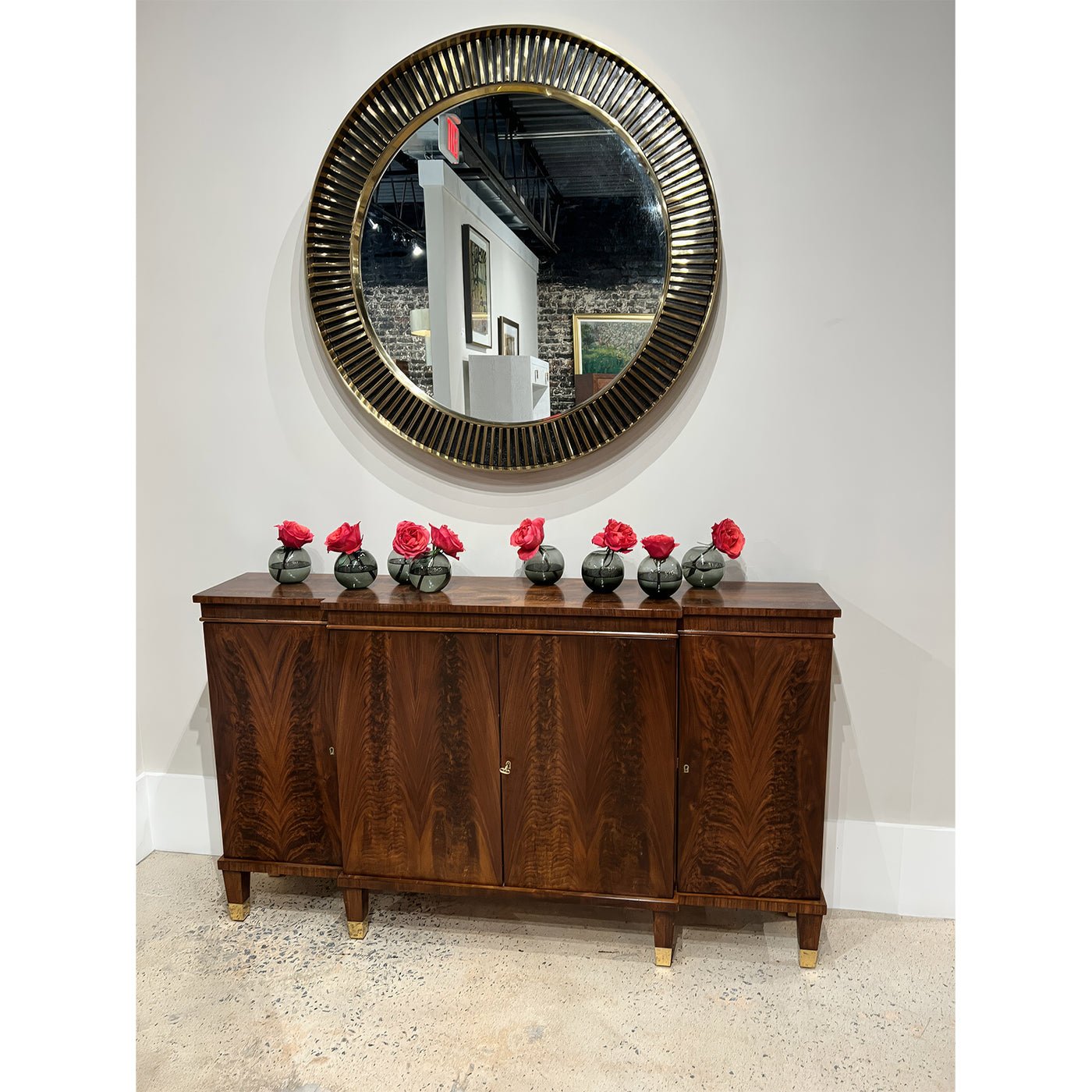 Regency walnut credenza with decorative flowers and round mirror.