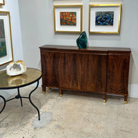 Regency walnut credenza alongside decorative table and mineral decor.