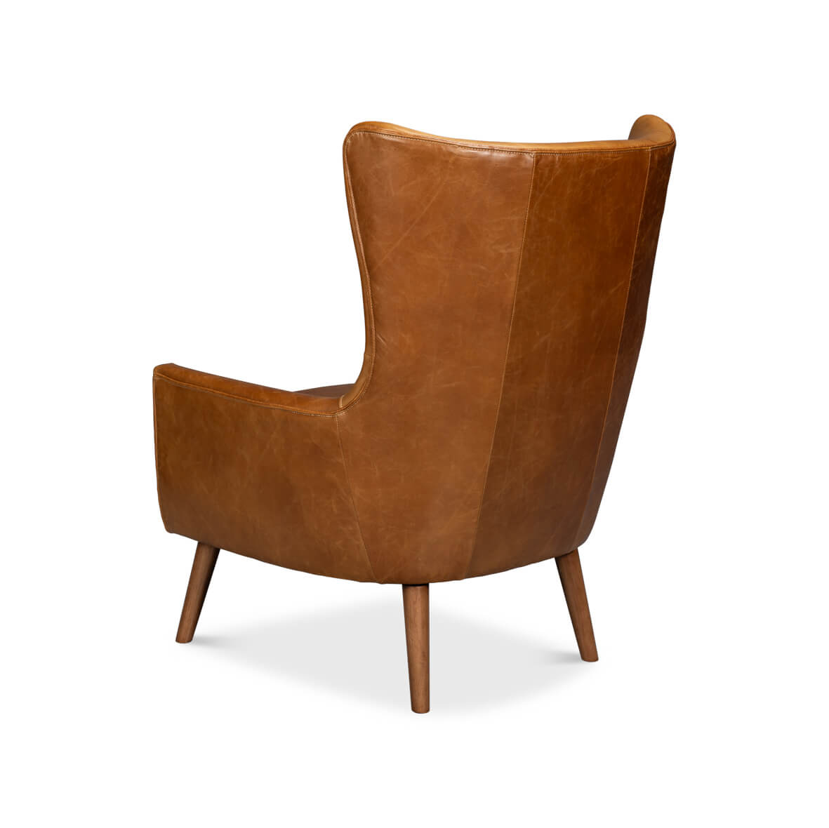 Rear-left angle of brown leather wingback chair, tall back.