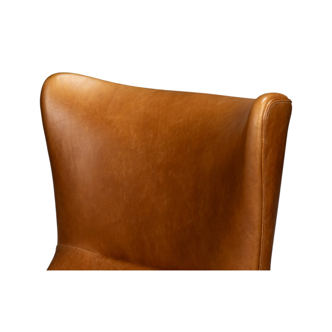 Upper backrest detail of brown leather wingback chair, curve.