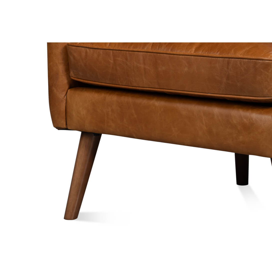 Leg detail, close-up of brown leather wingback chair.