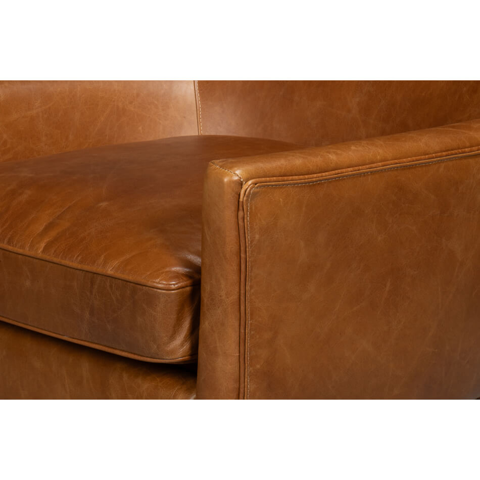 Armrest detail, side view, brown leather wingback chair.