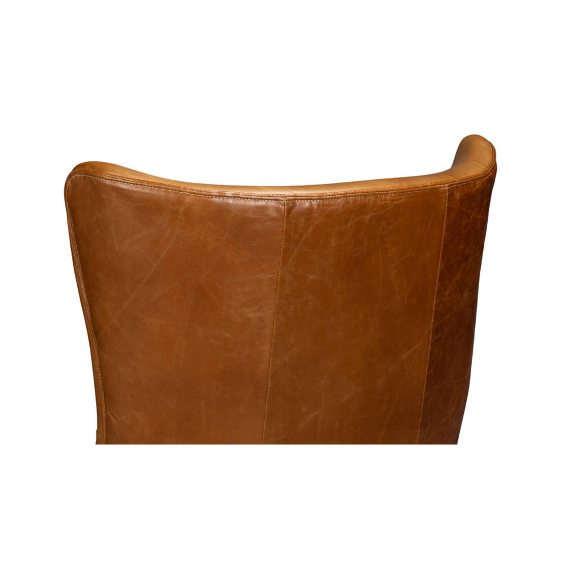 Backrest detail of brown leather wingback chair, stitching visible.