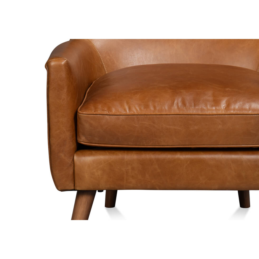 Close-up cushion detail of brown leather wingback chair seat.