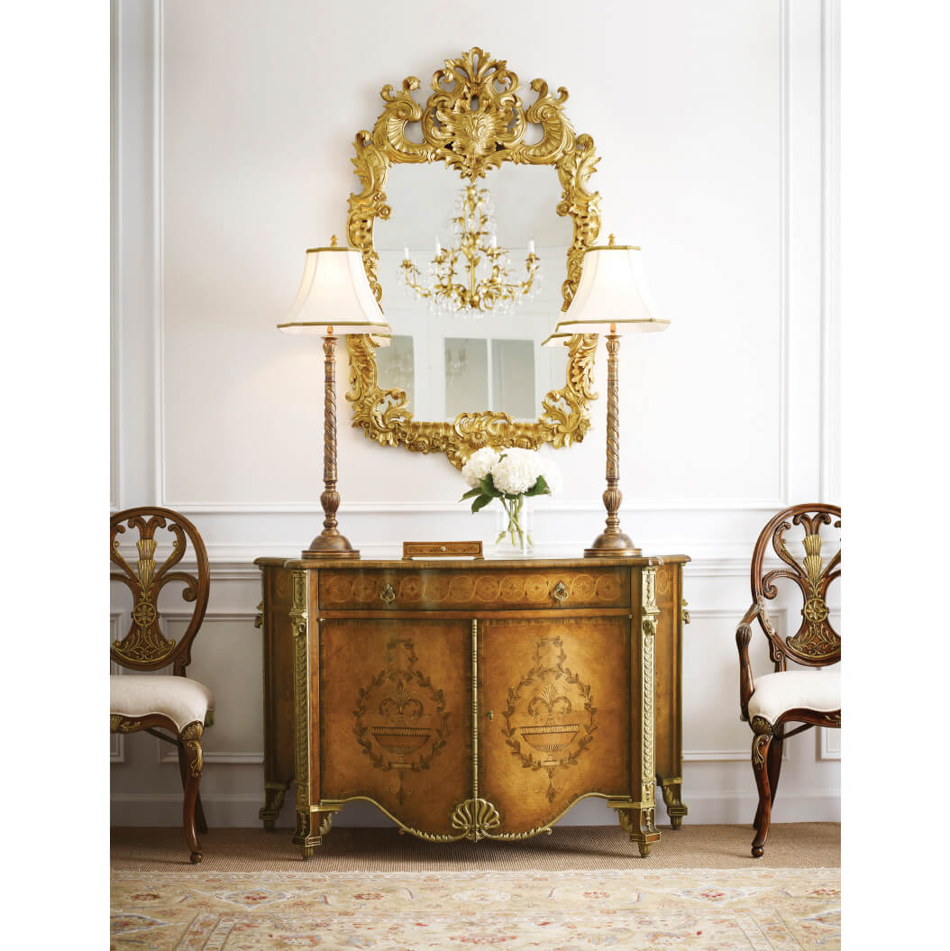 Rococo giltwood mirror above console with decor.
