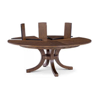 Round oak dining table with extended leaf inserts.
