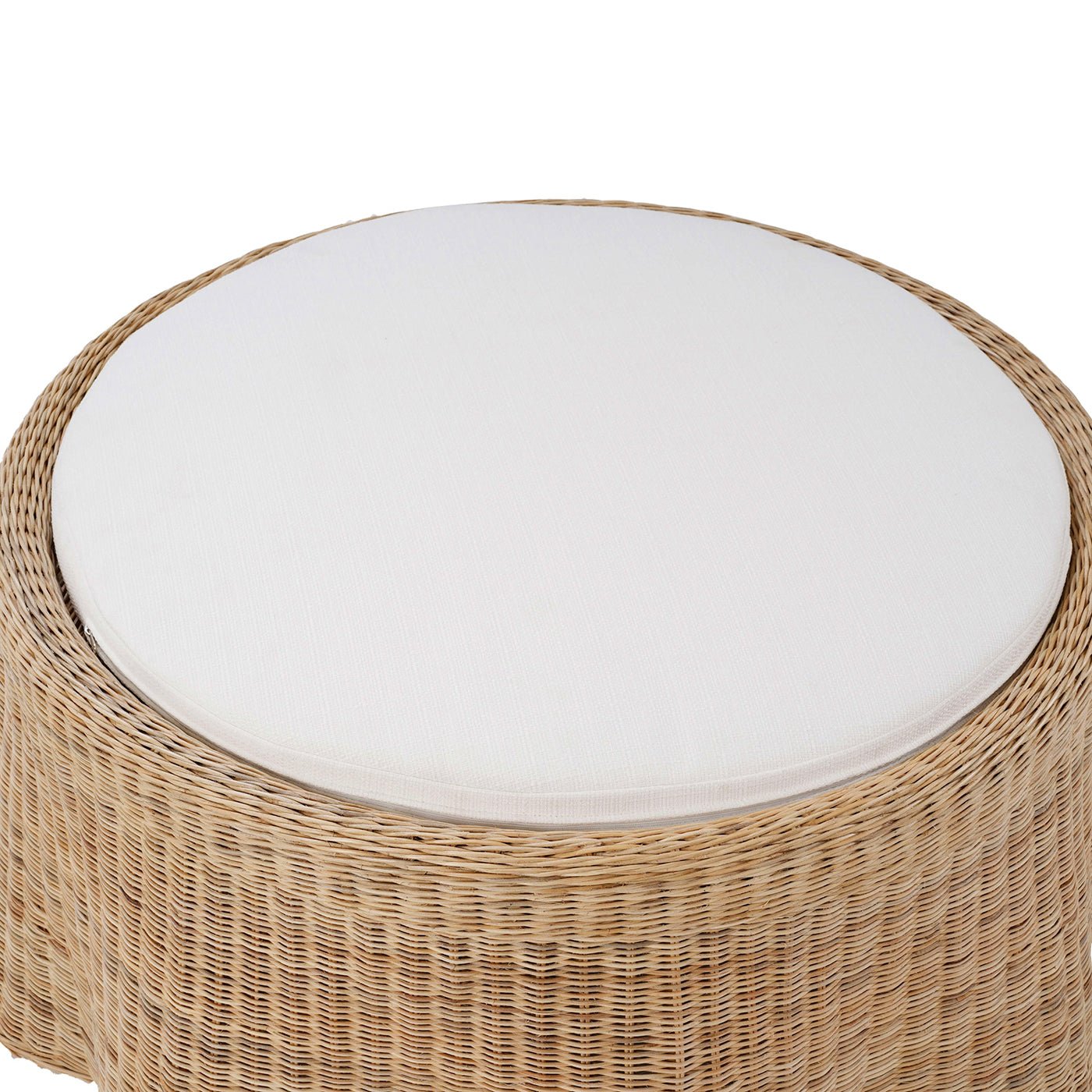 Close-up of white cushion on rattan ottoman.