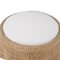 Close-up of white cushion on rattan ottoman.