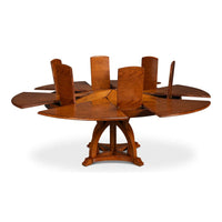 Leaf inserts being deployed in round walnut dining table.
