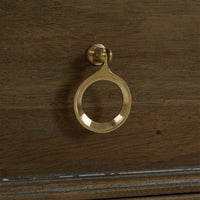 Brass handle on rustic commode drawer, close-up.
