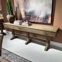 Rustic oak hunt table styled with decor in showroom.